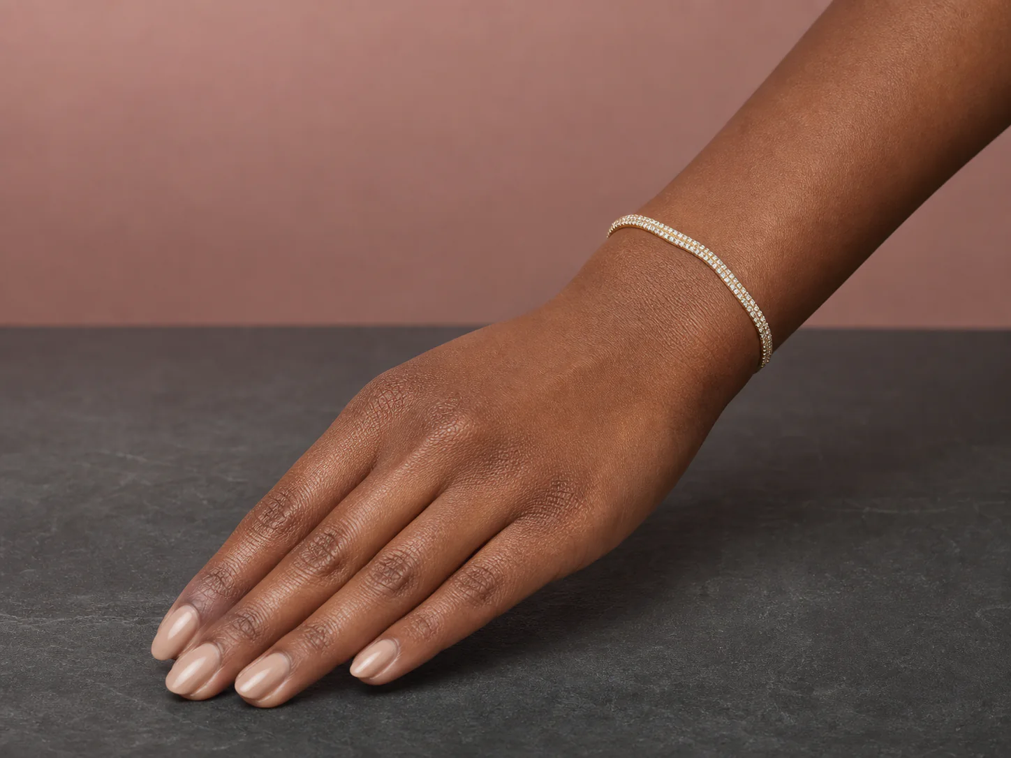 Editorial wrist styling with a gold-tone crystal tennis bracelet